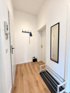 Flur einer Ferienwohnung mit Garderobe, Spiegel und Sitzbank