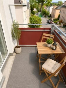 Balkon mit Holztisch und Sitzplätzen