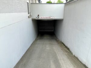 Abfahrt zur Tiefgarage zwischen weißen Wänden