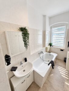 Badezimmer einer Ferienwohnung mit Badewanne und Fenster