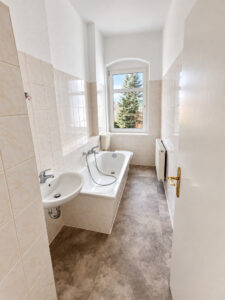 Schmales Badezimmer mit Badewanne und Fenster