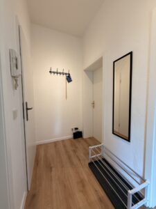 Flur einer Ferienwohnung mit Garderobe, Spiegel und Sitzbank