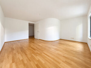 Helles Zimmer mit geschwungener Trennwand und großen Fenstern
