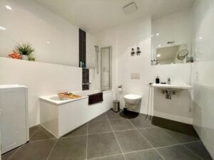 Modernes Badezimmer mit Badewanne, Dusche und Waschbecken