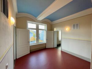 Hausflur mit farbig gestalteter Decke und rotem Boden