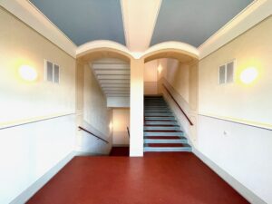 Treppenhaus mit farbig gestalteten Deckenbögen
