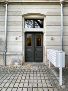 Hauseingang mit dunkler Holztür und Briefkastenanlage