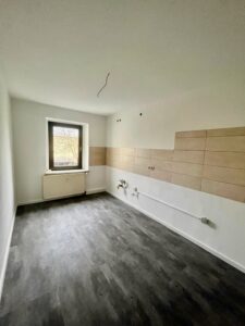 Unmöblierte Küche mit Fliesenspiegel und Fenster