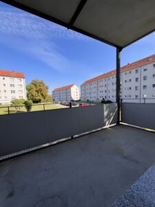 Überdachter Balkon mit Blick auf benachbarte Wohnhäuser