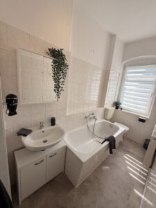 Badezimmer einer Ferienwohnung mit Badewanne und Fenster