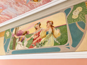 Historische Wandmalerei mit Figuren und floralen Ornamenten