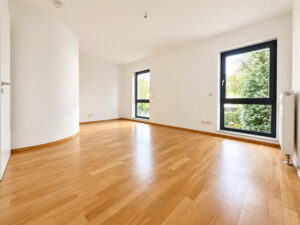 Helles Zimmer mit geschwungener Trennwand und großen Fenstern
