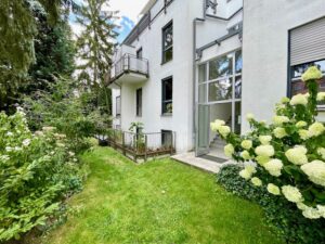 Gartenseite eines Wohnhauses mit blühenden Pflanzen