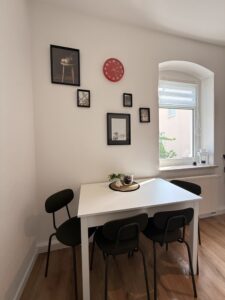 Kleiner Essplatz mit Tisch und Stühlen am Fenster