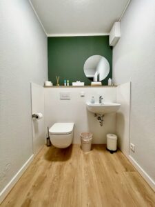 Gäste-WC mit Waschbecken und rundem Spiegel